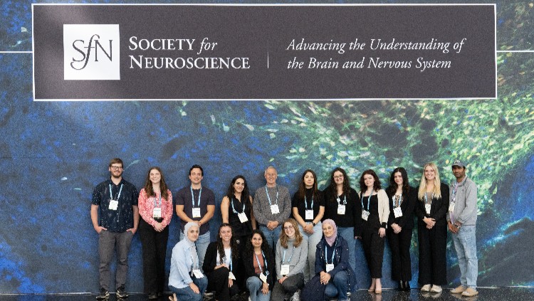 Members taking photos in front a SfN sign