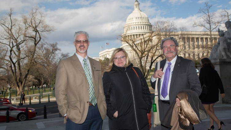 Three NeuroAdvocates pose in front of the US Capitol building